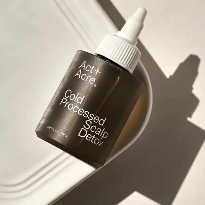 Act + Acre Cold Processed Scalp Detox bottle lying on a white surface, showing minimalistic and modern packaging.
