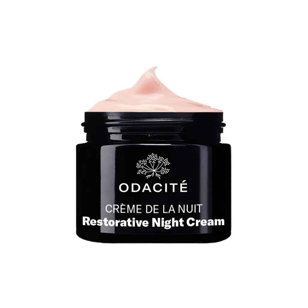 Odacité Crème de la Nuit Restorative Night Cream in a black glass jar with soft pink whipped texture, designed to hydrate and rejuvenate skin overnight.